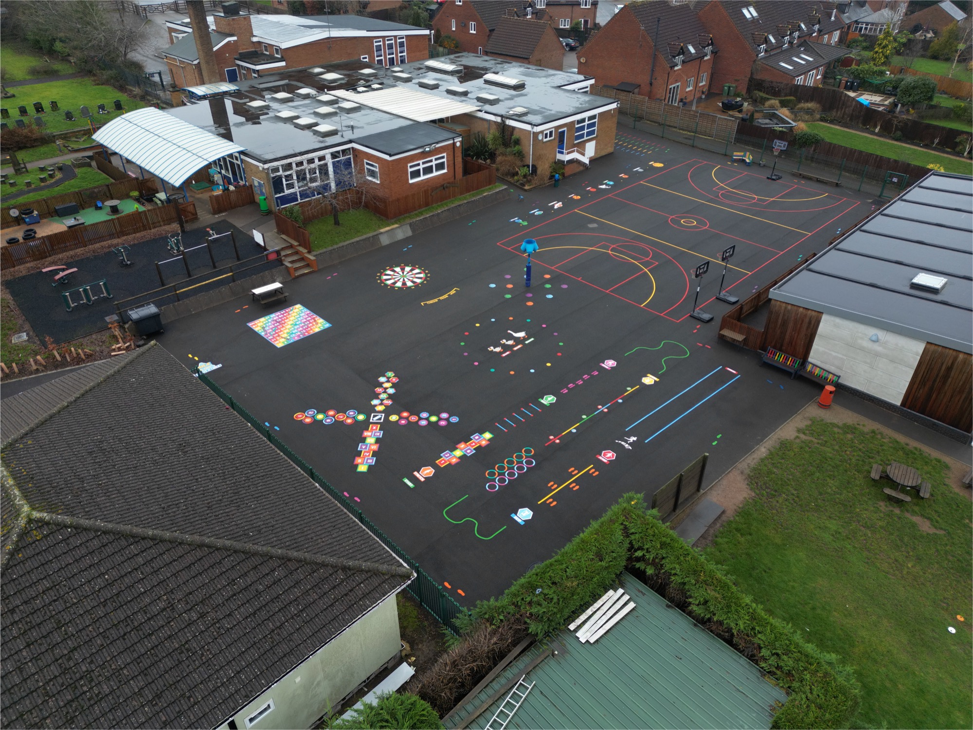 Aerial view of a school playground fully marked out by Uniplay with sports courts, number grids, trails and games