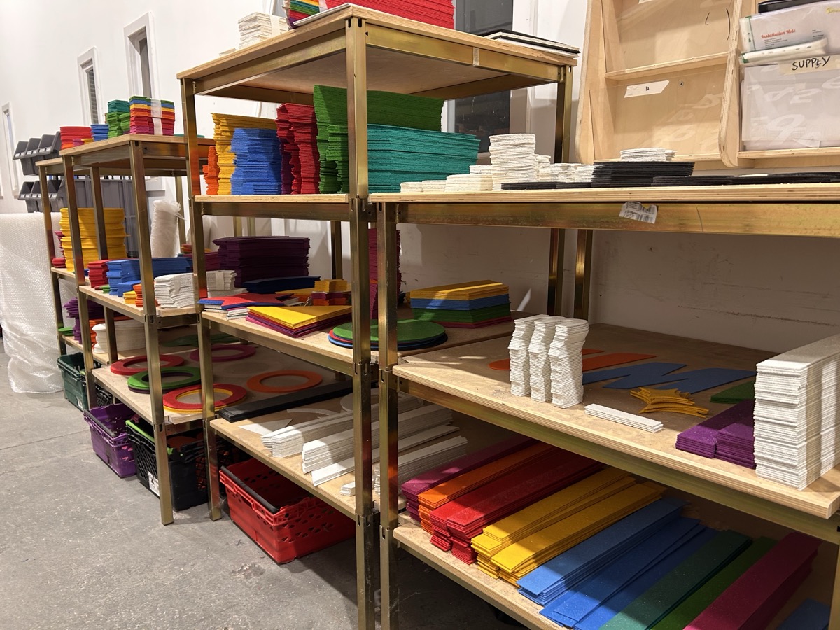 Pre-cut thermoplastic marking pieces on the shelves in the Uniplay workshop