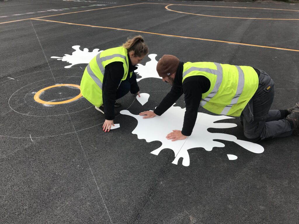 Uniplay team installing bright thermoplastic markings on a school playground